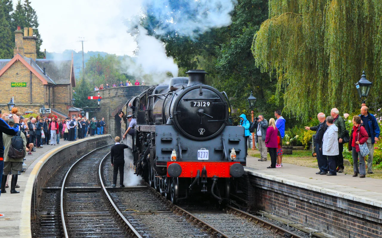 A railway worker exchanging a token with the crew of a steam locomotive at Arley station